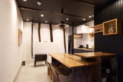 a kitchen with a large wooden table in a room at OldbutNew 蔵 in Hara