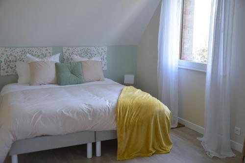 Les chambres du Vert Galant "Coucher de soleil" في Verlinghem: غرفة نوم عليها سرير مع بطانية صفراء