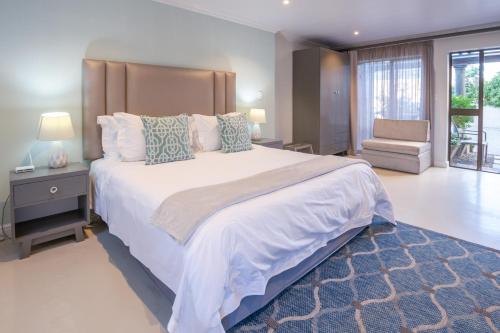 a large bedroom with a large bed and a chair at Chateau de Marine Boutique Hotel in Struisbaai