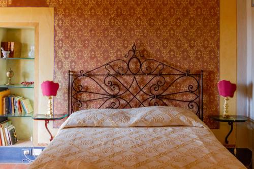 a bedroom with a bed with two lamps and books at Antica Dimora Leones in Palaia