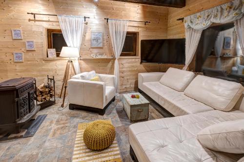 a living room with a couch and a flat screen tv at Zlatiborski katuni in Zlatibor