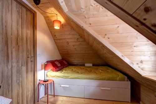 a bed in a wooden room with a staircase at Zlatiborski katuni in Zlatibor
