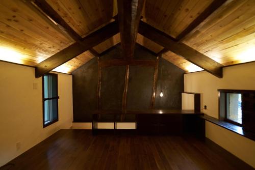 an empty room with wooden ceilings and wooden floors at OldbutNew 蔵 in Hara