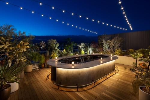 a hot tub on a deck at night with lights at NOHGA HOTEL KIYOMIZU KYOTO in Kyoto