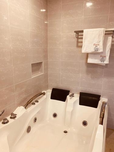a white bath tub in a bathroom with towels at Flora Hotel Ivato International Airport in Antananarivo