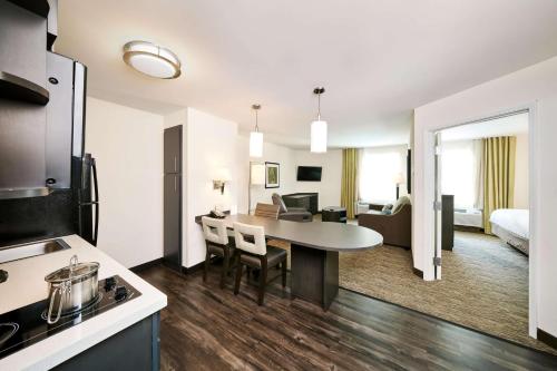 Sonesta Simply Suites Pittsburgh Airport في Imperial: مطبخ وغرفة معيشة مع طاولة في غرفة