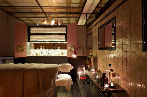 a room with a bed and a table and chairs at QT Sydney in Sydney