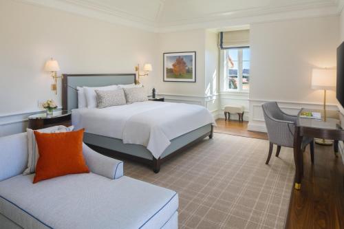 a bedroom with a bed and a desk and a couch at Keswick Hall in Charlottesville