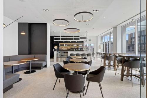 a dining room with tables and chairs and windows at Wyndham Garden Christchurch Kilmore Street in Christchurch