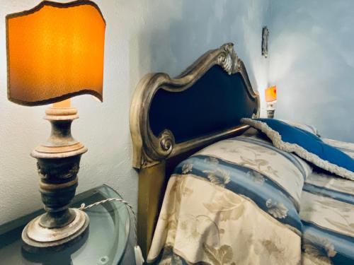 a bedroom with a bed with a lamp next to it at Antica Dimora Leones in Palaia
