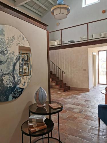a living room with two tables and a staircase at Palazzo Maresgallo Suites & SPA in Lecce