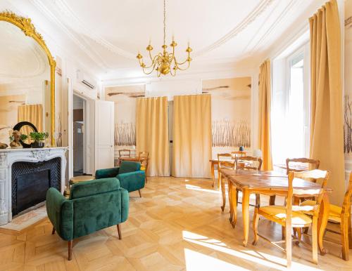 - un salon avec une table, des chaises et une cheminée dans l'établissement Berti Hotel - Mulhouse Centre Gare, à Mulhouse