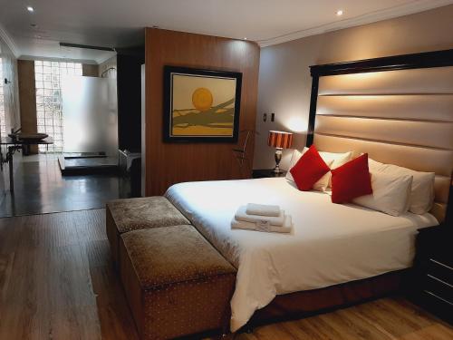 a bedroom with a large white bed with red pillows at African Moon Corporate House in Kempton Park