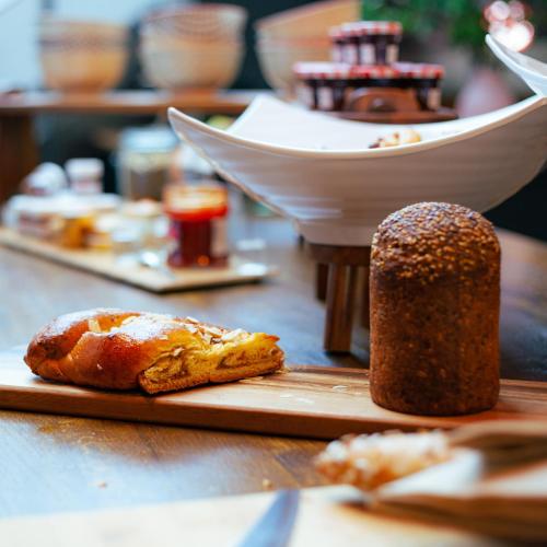 a table with bread and other food items on it at Berti Hotel - Mulhouse Centre Gare in Mulhouse