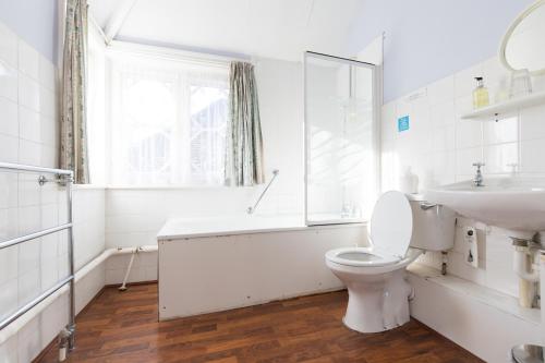 a white bathroom with a toilet and a sink at Foxlease in Lyndhurst