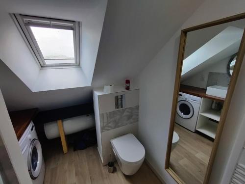uma casa de banho no sótão com um WC e uma janela em Appartement T3 "YUCA" Hyper centre d'ERNÉE em Ernée