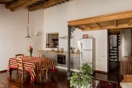 een keuken met een tafel met stoelen en een koelkast bij Monti Sweet Apartment in Rome