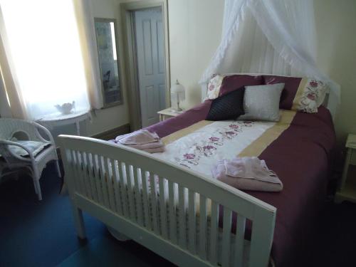 a white crib in a bedroom with a canopy at Astonleigh Villa Bed & Breakfast in Te Awamutu