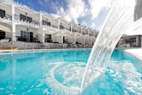 a swimming pool filled with water with a blue sky at Vista Bonita - Gay and Lesbian Only Resort in Maspalomas