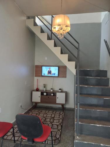 a living room with a television and a stair case at Noite hotel in Palmas