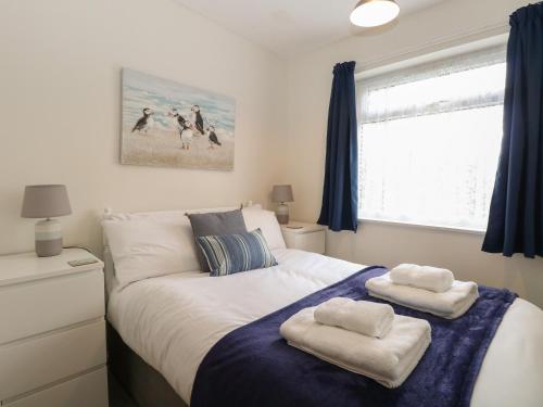 a bedroom with a bed with towels on it at 14 Siesta Mar in Norwich