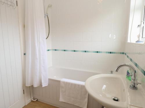 a white bathroom with a sink and a bath tub at 14 Siesta Mar in Norwich