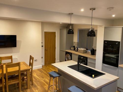 a kitchen with a table and a dining room at The Wootton House in Doncaster