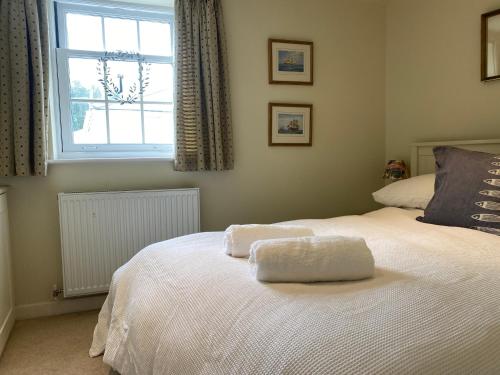 um quarto com 2 camas e uma janela em Reduced rates for this month! Beautiful cottage, 3 stories high with upstairs courtyard and set in an amazing location! The fantastic newly developed Town Mill with restaurants and craft shops on your doorstep Also only 2 minutes to the sea! , Sleeps 4 em Lyme Regis
