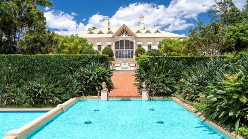 an estate with a swimming pool in front of a house at InterContinental Sanctuary Cove Resort by IHG in Gold Coast