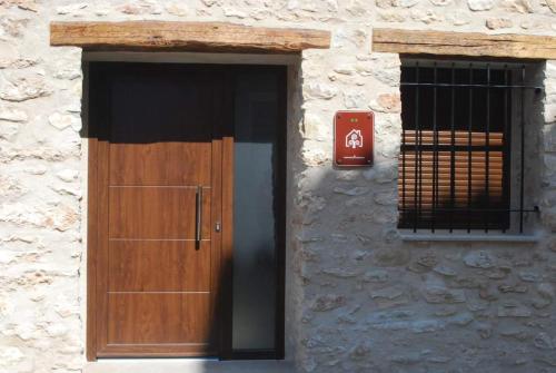 un edificio con una puerta de madera y una ventana en Casa Rural Carmen Atzeneta, en Adzaneta