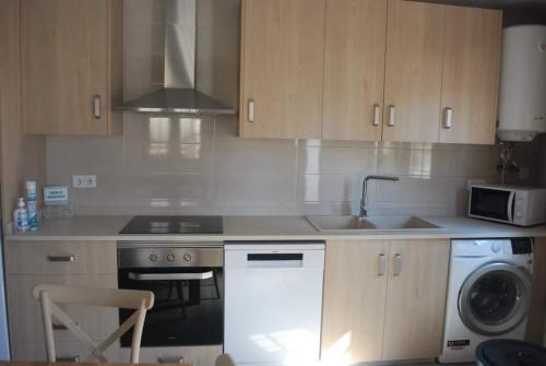 a kitchen with a sink and a stove and a dishwasher at Casa Rural Carmen Atzeneta in Adzaneta