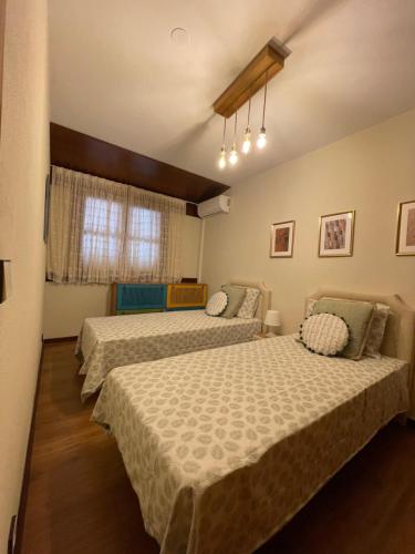 a bedroom with two beds and a window at Casa da Bia in Quarteira
