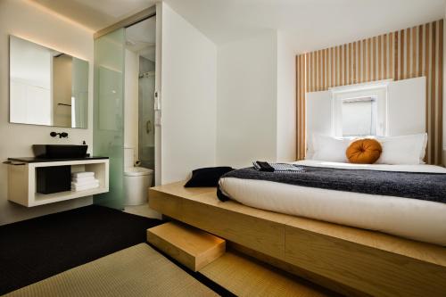 a bedroom with a large bed and a bathroom at Viseu Ryokan - Hospedaria Japonesa & SPA in Viseu
