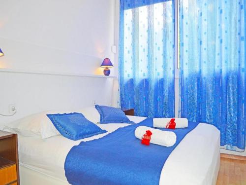 Un dormitorio con una cama azul y blanca con almohadas azules en Apartments Kate, en Makarska