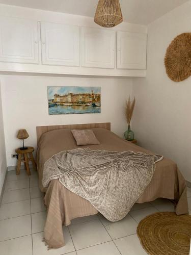 une chambre avec un lit et un tableau au mur dans l'établissement Superbe appartement cosy vue mer pieds dans l’eau, à Cavalaire-sur-Mer