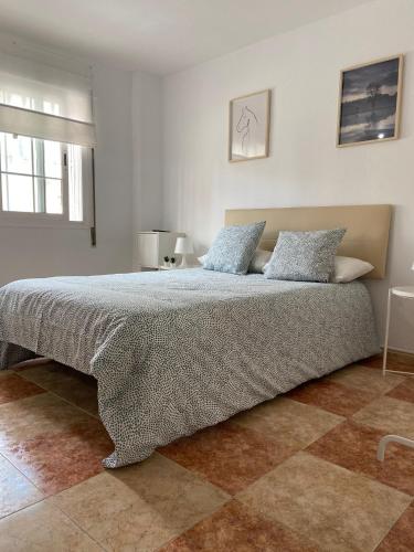 1 dormitorio con 1 cama grande y 2 almohadas en Estudio Malagueño Centro 1ºB, en Málaga