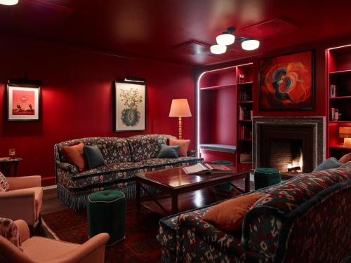 a red living room with couches and a fireplace at 25hours Hotel Indre By in Copenhagen