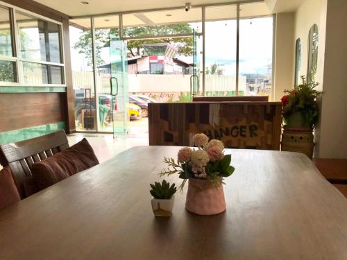 a wooden table with a vase of flowers on it at Sun Moon Hotel in Loei