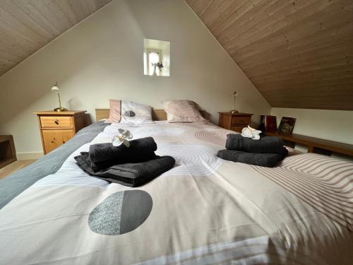 een slaapkamer met een groot bed en handdoeken bij PENTY DU BELOU, cozy, en pleine campagne, 1 à 6 personnes in Mellac