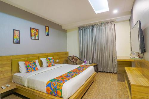 a bedroom with a bed and a flat screen tv at FabHotel Prime Z Grand in Ludhiana