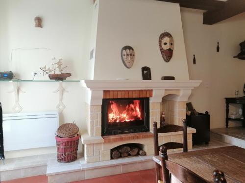 uma lareira numa sala de estar com lareira em Grande maison de ville avec cheminée et loggia em Lacapelle-Biron