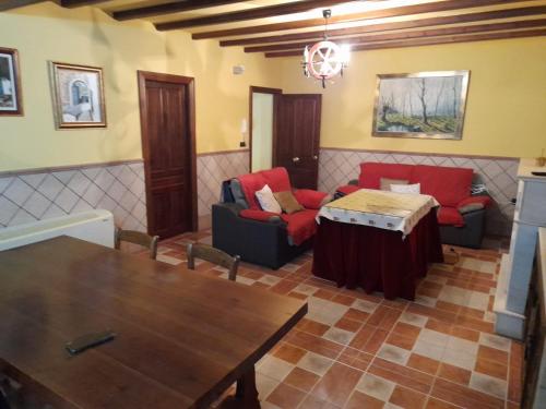 ein Wohnzimmer mit roten Stühlen und einem Tisch in der Unterkunft APARTAMENTO SAN CARLOS in Baena