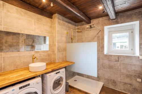 - une buanderie avec un lave-linge et un sèche-linge dans l'établissement LA LONGERE DU TERTRE - Charmante longère de 400m2 proche plage, à Cancale