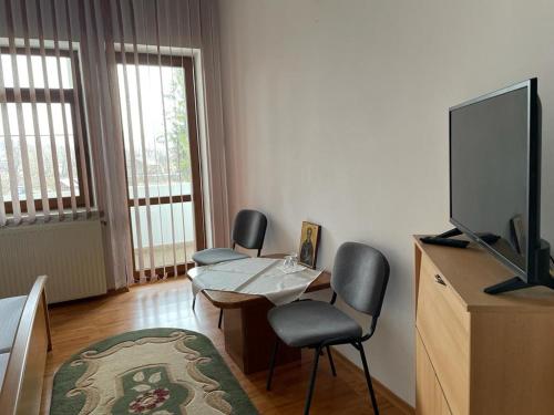 a living room with two chairs and a table and a television at Casa de Pelerinaj Ierusalim Hozeva in Mînăstirea Neamţ