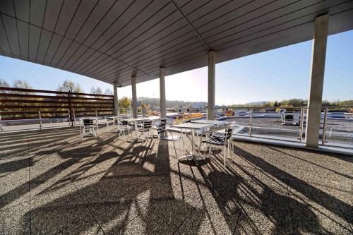 a group of tables and chairs on the roof of a building at Charme Hôtel, Montbéliard Sud in Montbéliard