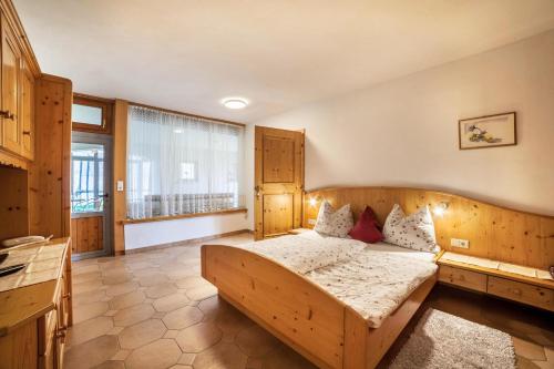 1 dormitorio con cama de madera y ventana grande en Camping Passeier Löwenzahn, en Saltusio
