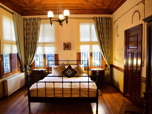 ein Schlafzimmer mit einem Bett in einem Zimmer mit Fenstern in der Unterkunft Ottoman Suites by Sera House in Istanbul