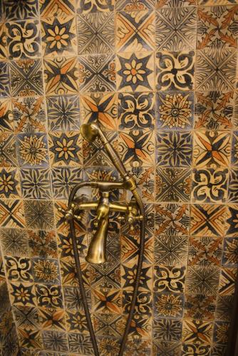 a brass shower head on a tiled wall at Ottoman Suites by Sera House in Istanbul