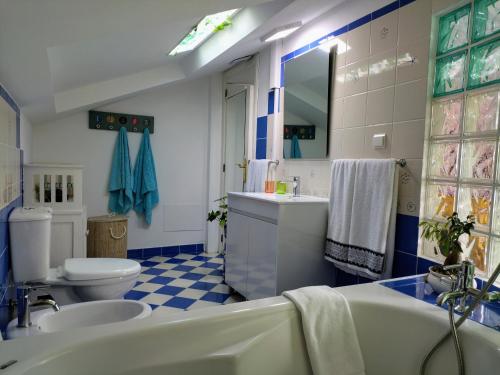 un bagno blu e bianco con vasca e servizi igienici di ATTIC BAY a Câmara de Lobos