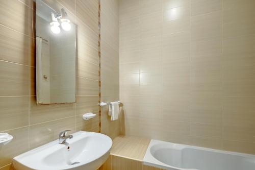 ein Badezimmer mit einem Waschbecken, einem Spiegel und einer Badewanne in der Unterkunft Modern 2 Bedroom Maisonette in Central Sliema in Sliema